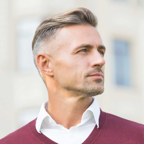 A man looking to the side with smooth hair-free ears after a laser hair removal treatment.
